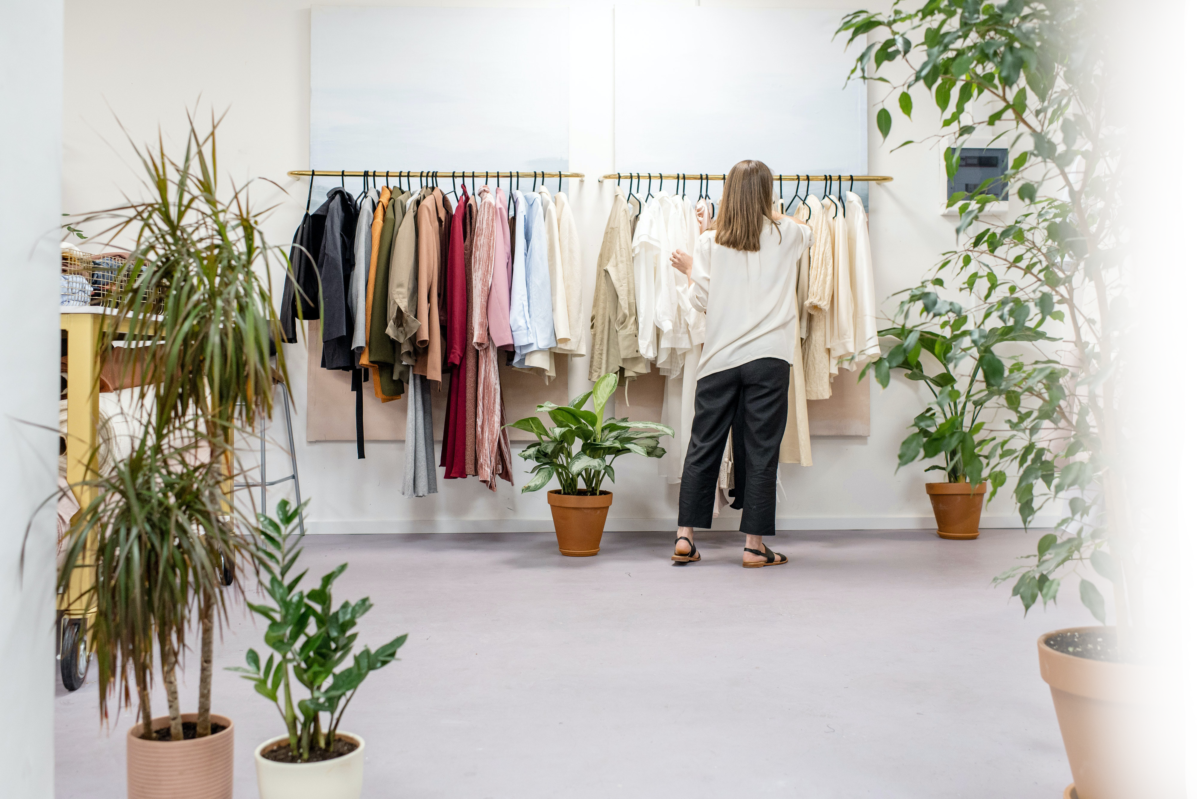 Woman shopping in clothing retail store listening to background music